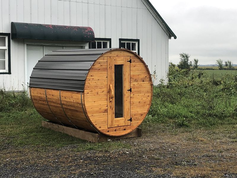 Wooden barrel sauna on a base in a garden