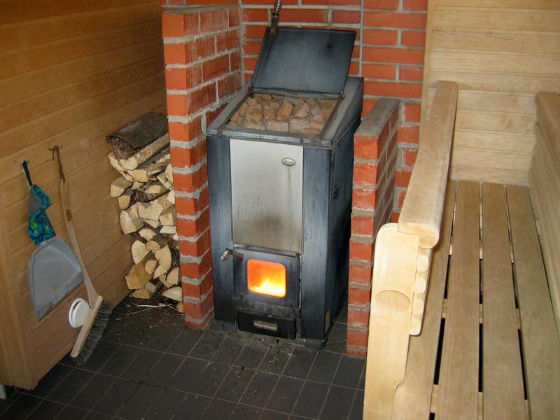 Holzbefeuerter Saunaofen mit Steinen in einer Holzsauna