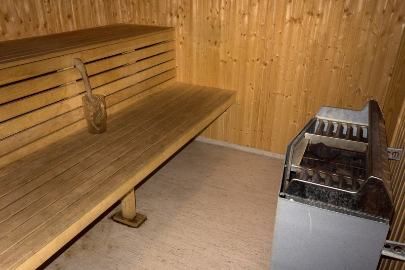 Sauna in legno con panca e stufa elettrica